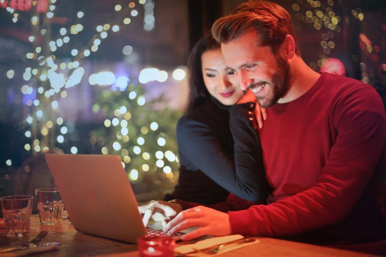 couple in front of computer smiling